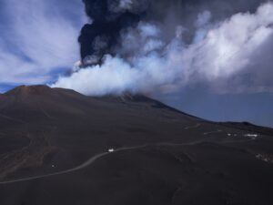 Snow-covered Mount Etna erupting with lava and smoke in Sicily