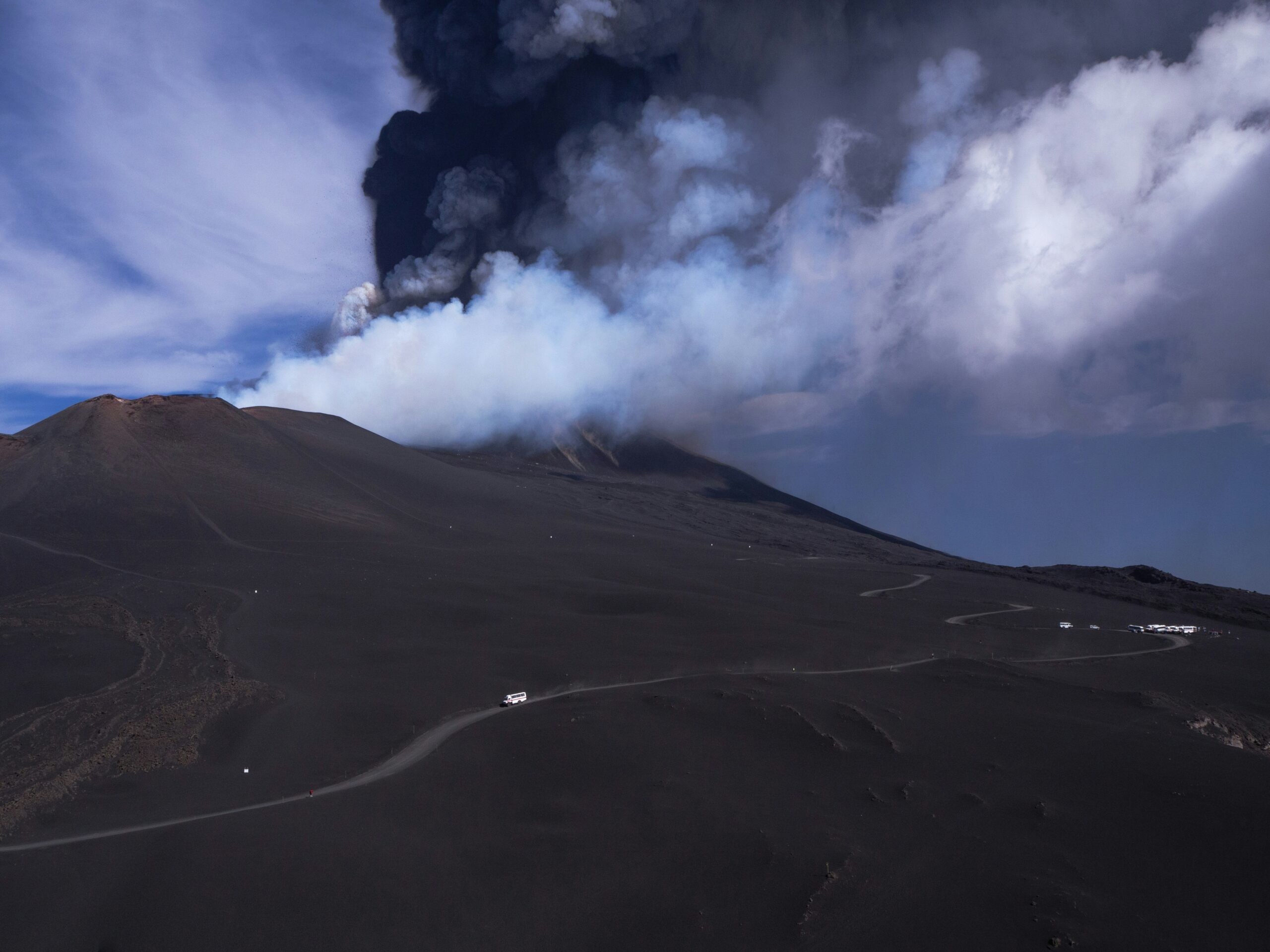 Snow-covered Mount Etna erupting with lava and smoke in Sicily